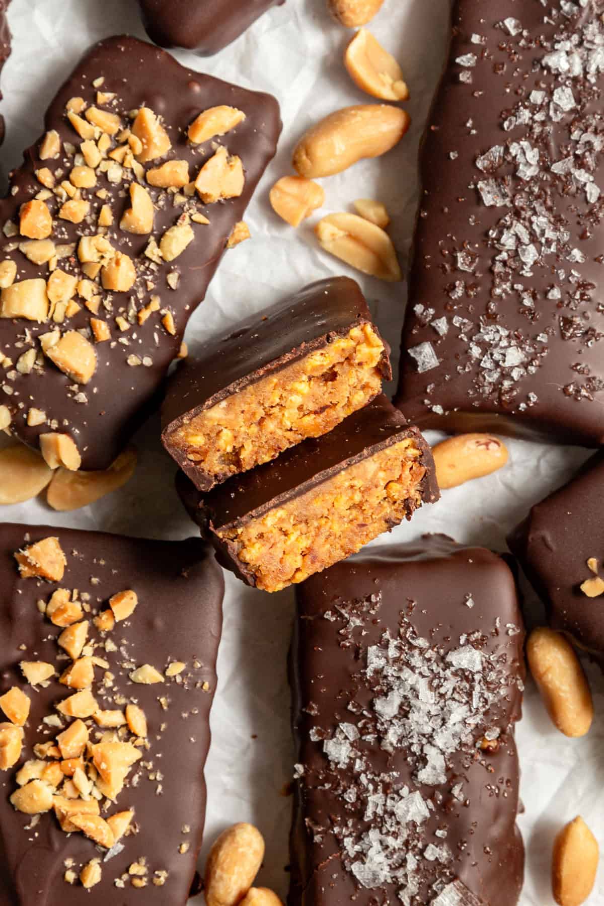 Several vegan butterfingers on a sheet of parchment paper, with peanuts.