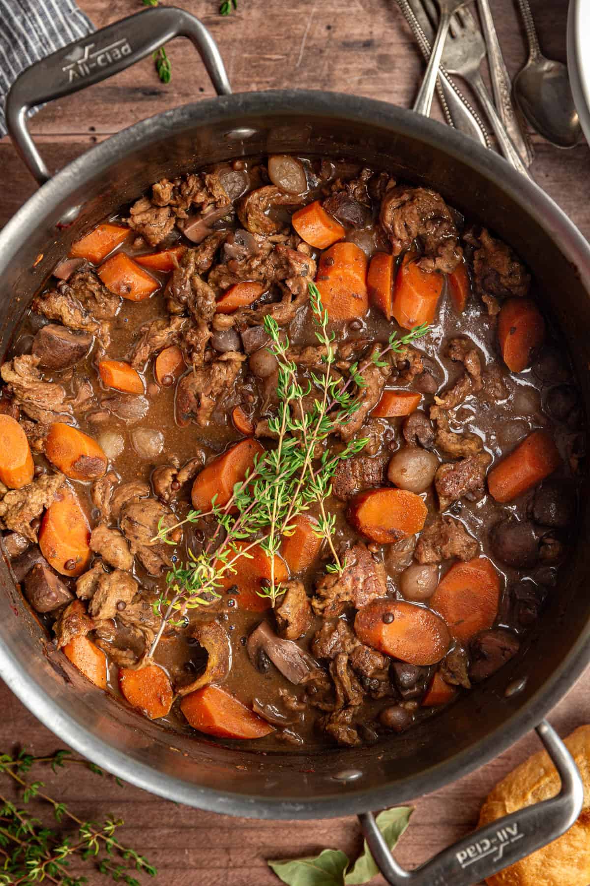 A pot of freshly prepared vegan coq au vin with a garnish of thyme.