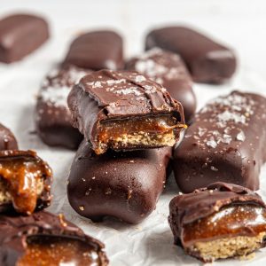Several vegan twix bars that have been bitten into, revealing the caramel and cookie layers.