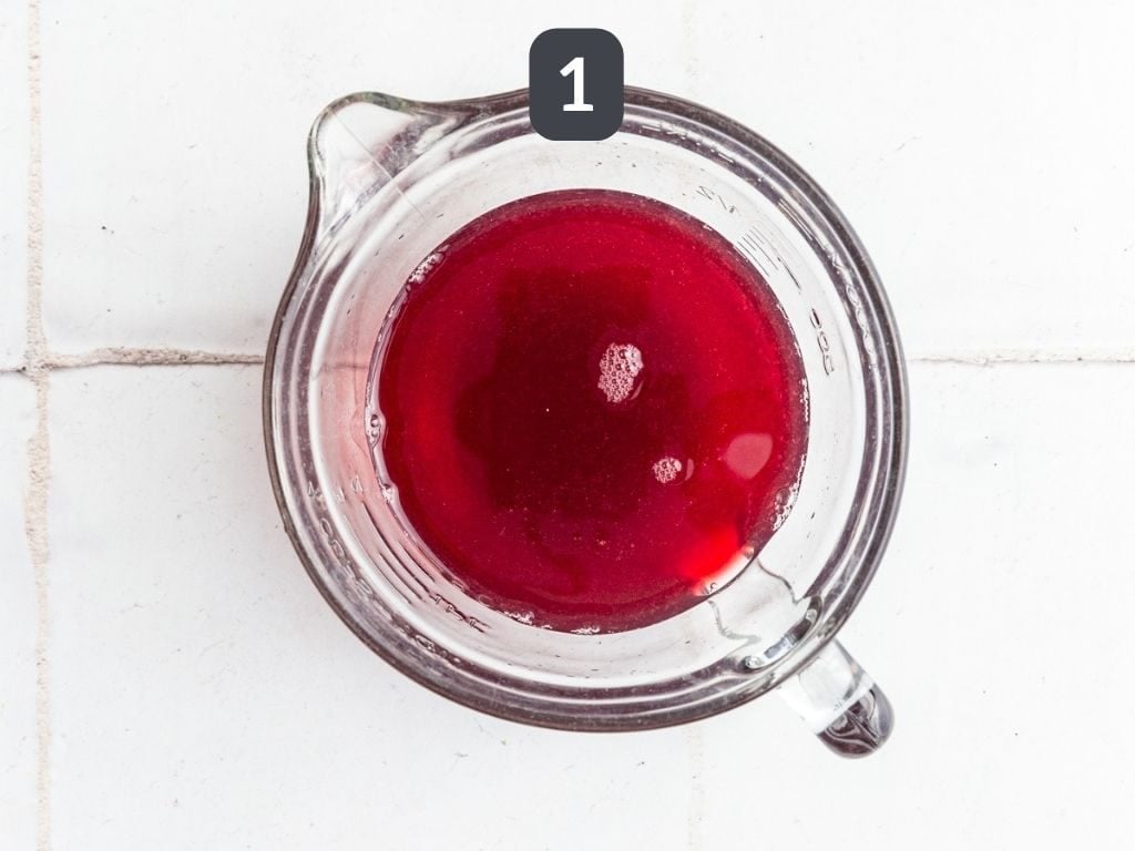 Cranberry Mule Mocktail Step 1 - mix the cranberry juice, alcohol-free vodka, and lime juice.