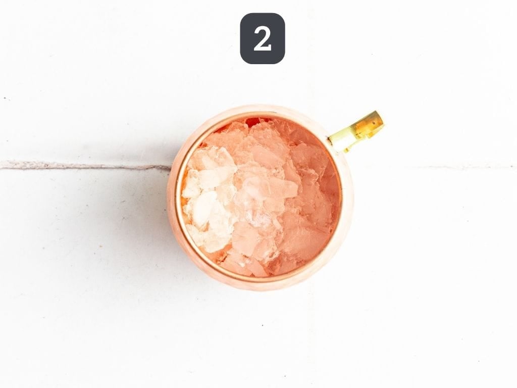 Cranberry Mule Mocktail Step 2 - add ice to a mule glass.