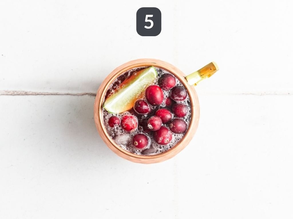 Cranberry Mule Mocktail Step 5 - garnish with lime wedges and frozen cranberries.