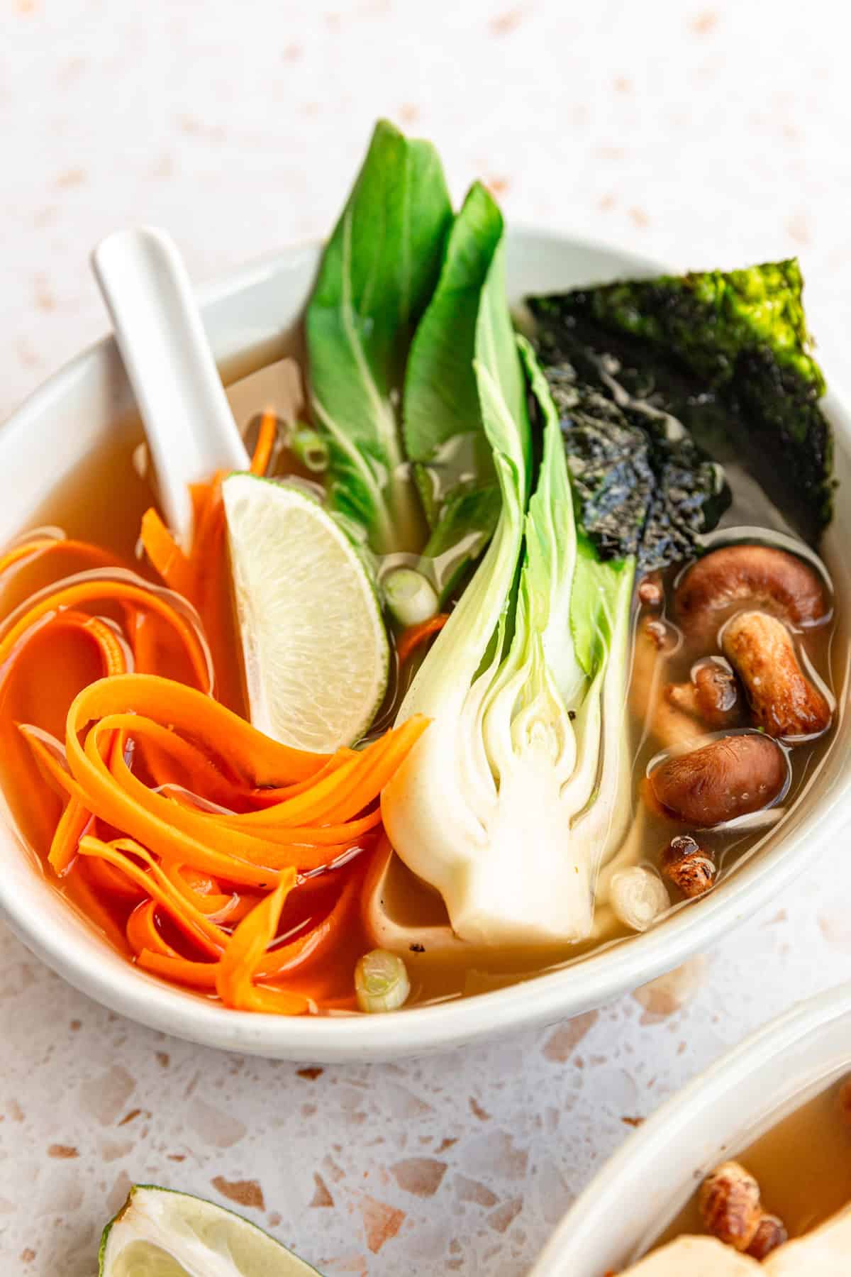 A bowl of miso soup with a large half of bok choy.
