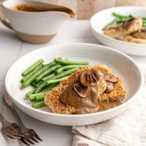 A bowl with tofu and gravy, served with green beans.