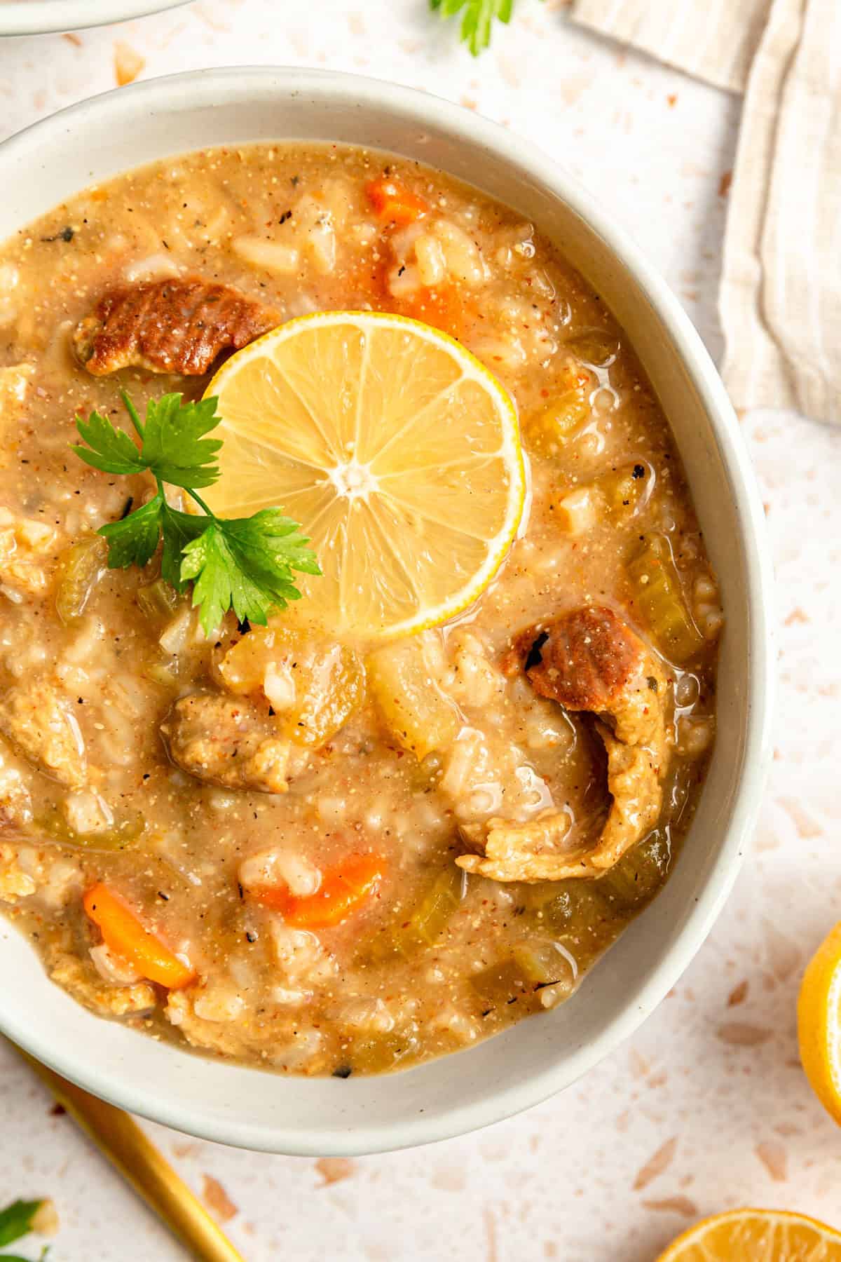 A bowl of Vegan Chicken Lemon Rice Soup, highlighting the chunky chicken pieces.