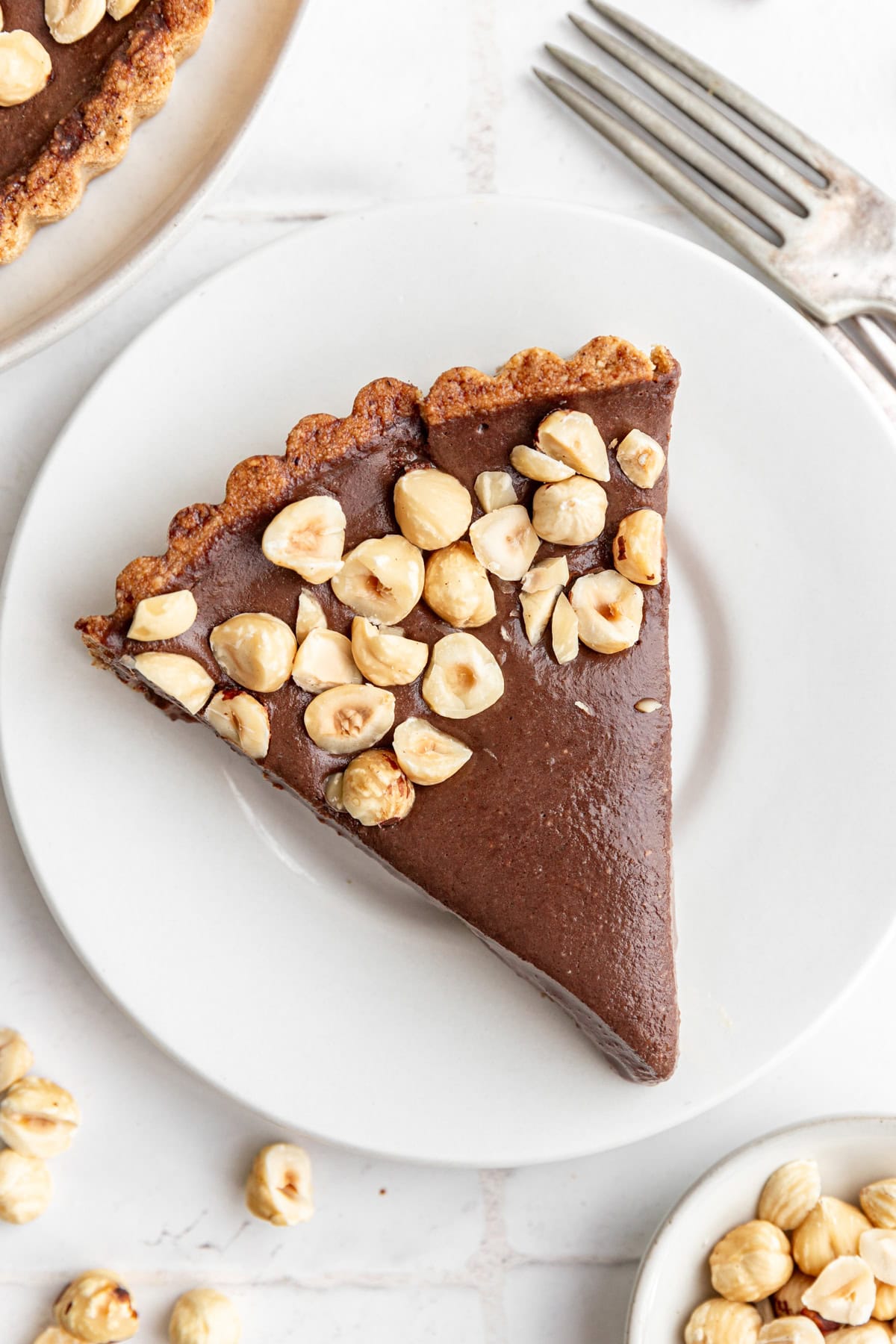 A large slice of Vegan Chocolate Hazelnut Tart on a plate.