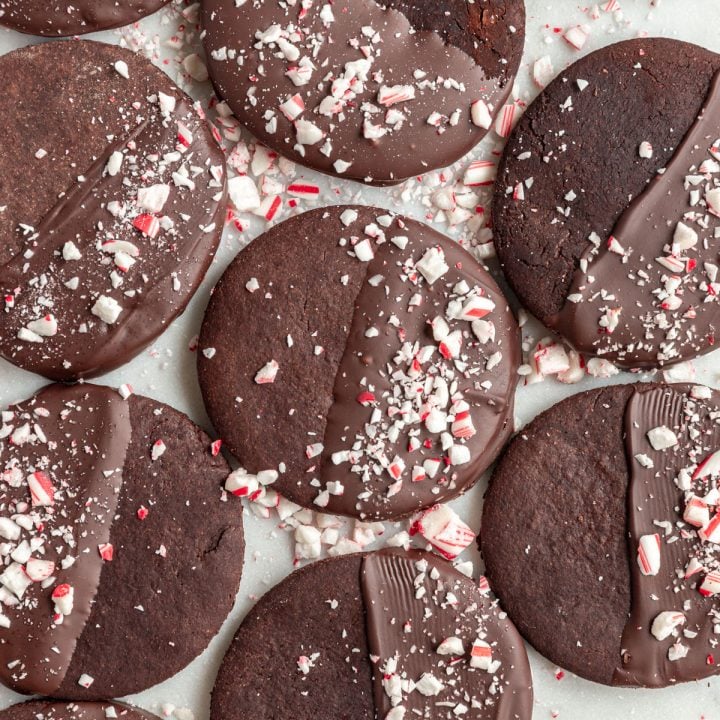 Vegan Chocolate Peppermint Cookies on a countertop, with extra candy canes sprinkled around.