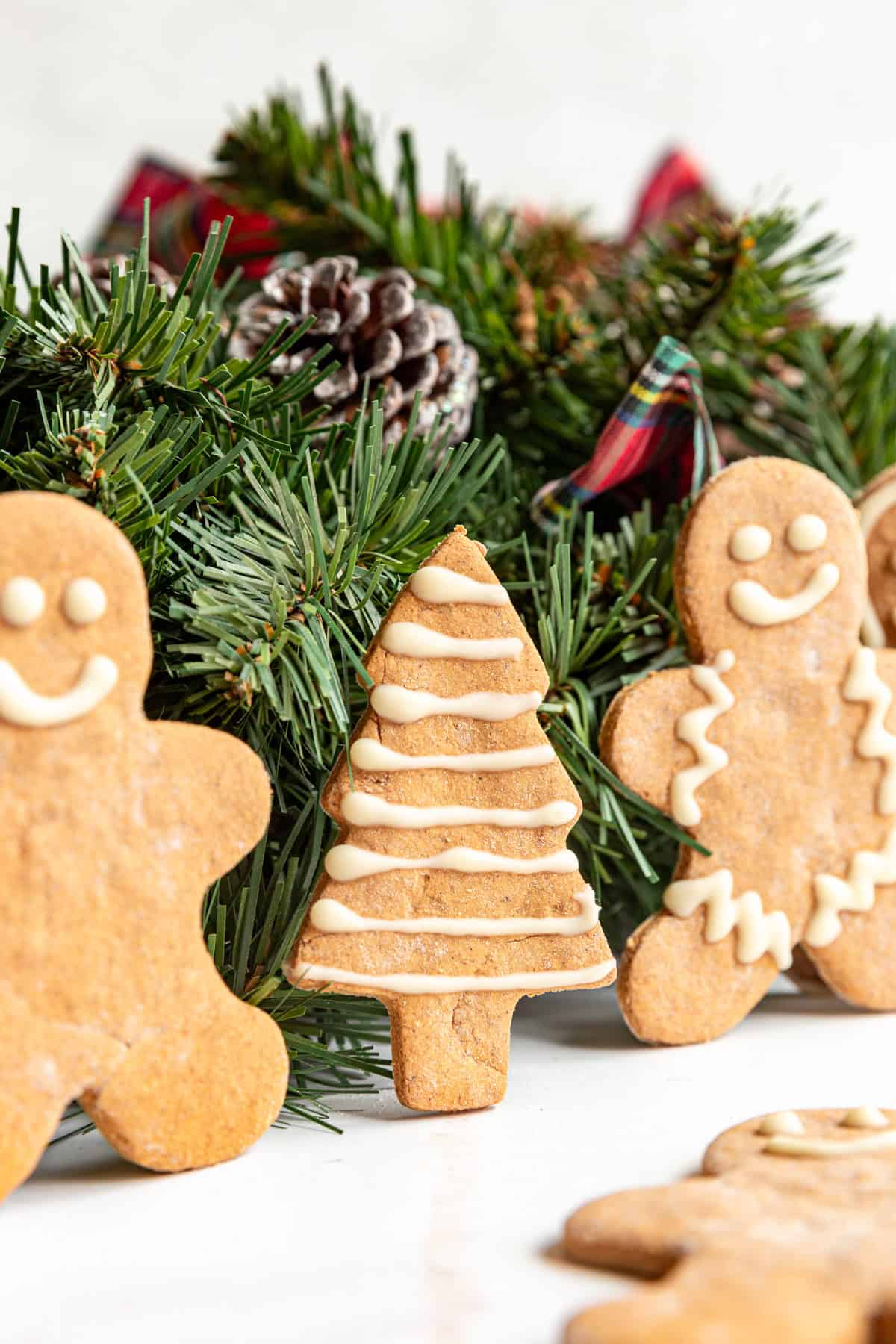 A gingerbread Christmas tree standing up next to Christmas garland.