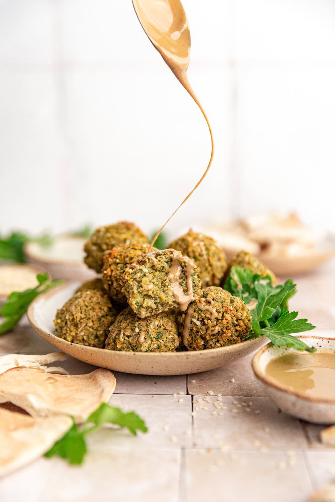 Vegan Oil-Free Falafel being drizzled with tahini