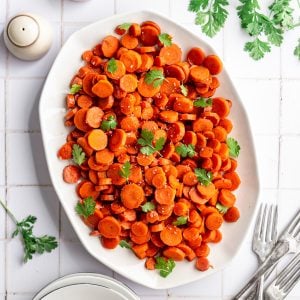 A platter of bourbon glazed carrots, topped with fresh cilantro.