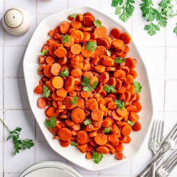 A platter of bourbon glazed carrots, topped with fresh cilantro.