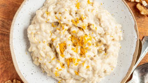 A bowl of bourbon orange rice pudding, garnished with orange zest.