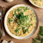 A bowl of chickpea yogurt soup garnished with dill.