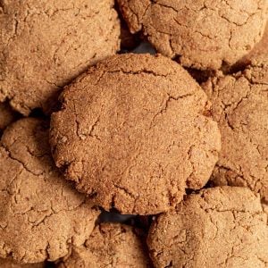 Ginger molasses cookies piled on a baking sheet.