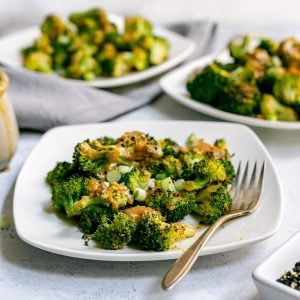 A plate of miso charred broccoli, with a fork, ready to serve.