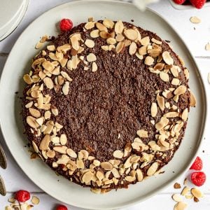 A chocolate almond torte on a plate, ready to serve.
