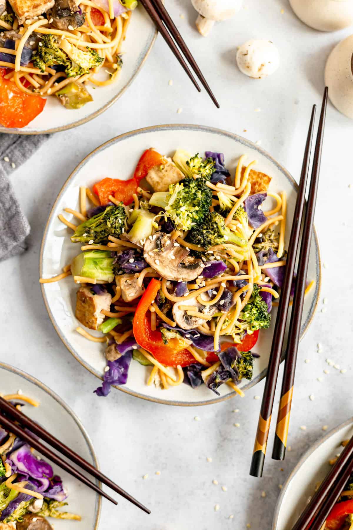 A plate of plant-based lo mein served with chopsticks.
