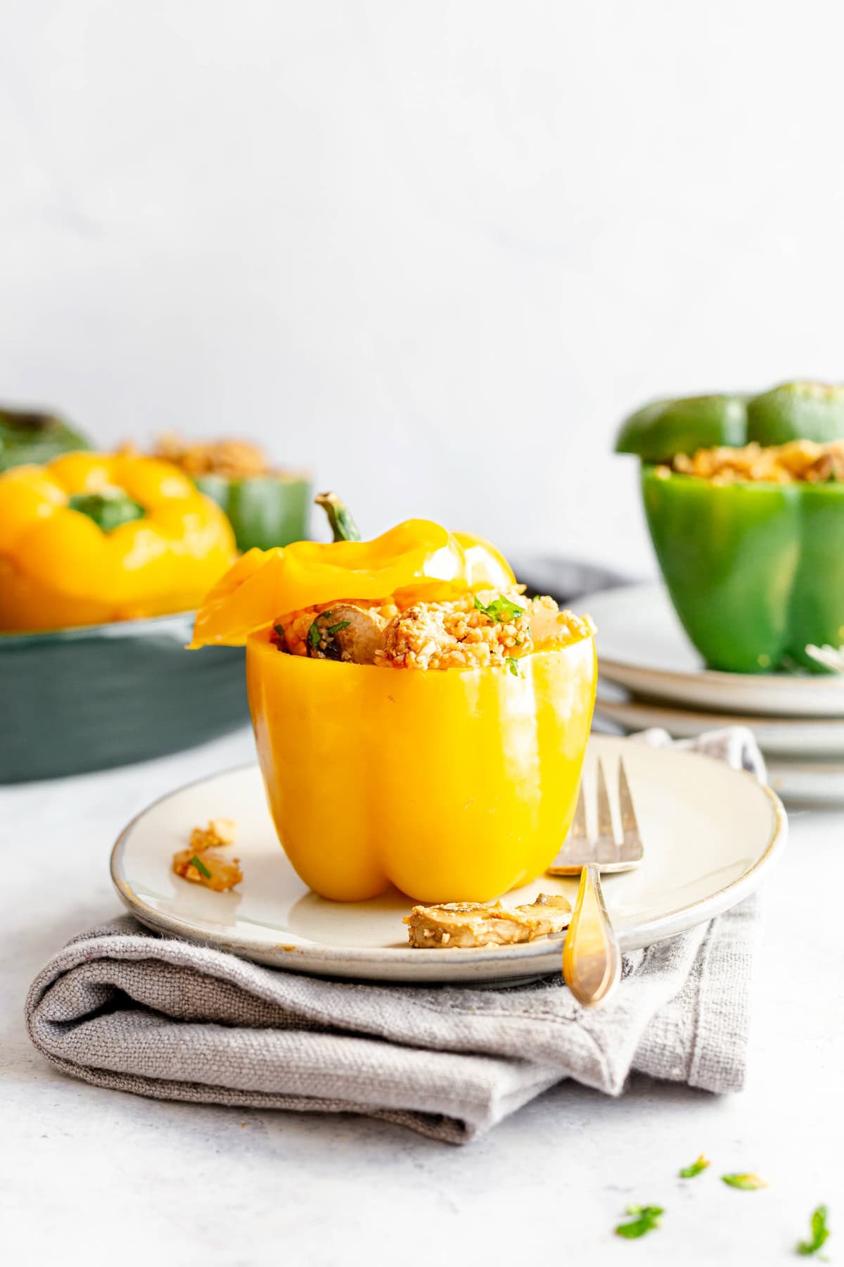 A yellow stuffed pepper on a plate with a fork, ready to serve.