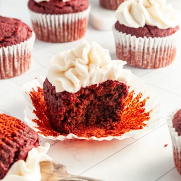 A red velvet cupcake with a forkful taken out.