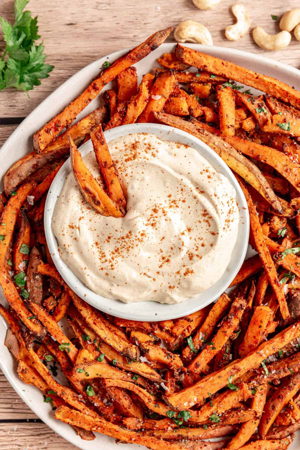 A platter of sweet potato fries with a dish of aioli.