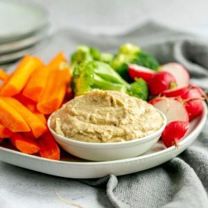 A plate of vegetables with a bowl of baba ganoush hummus.