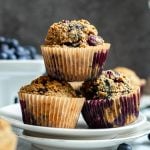 A plate of three blueberry muffins.