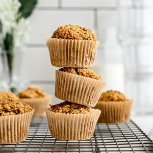 A stack of carrot cake banana muffins on a cooling rack.