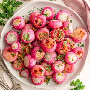 A plate of garlic roasted radishes sprinkled with fresh parsley.