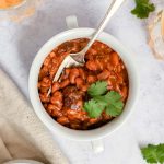 A bowl of maple bourbon pinto beans garnished with cilantro.