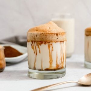 A glass of sugar free vegan whipped coffee with date syrup running down the sides.