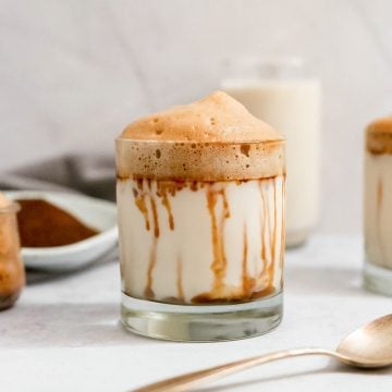 A glass of sugar free vegan whipped coffee with date syrup running down the sides.