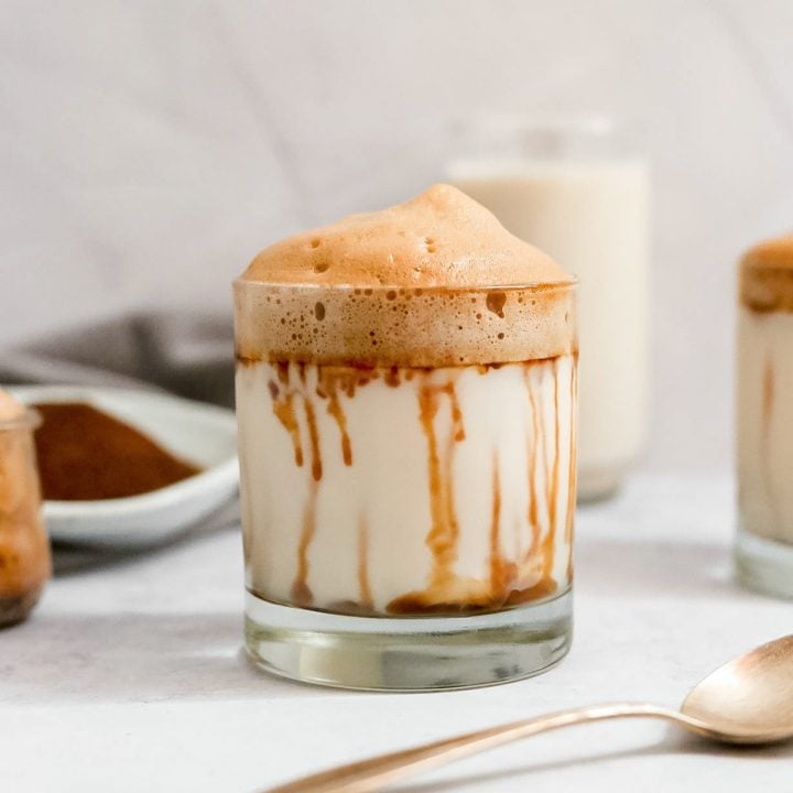 A glass of sugar free vegan whipped coffee with date syrup running down the sides.