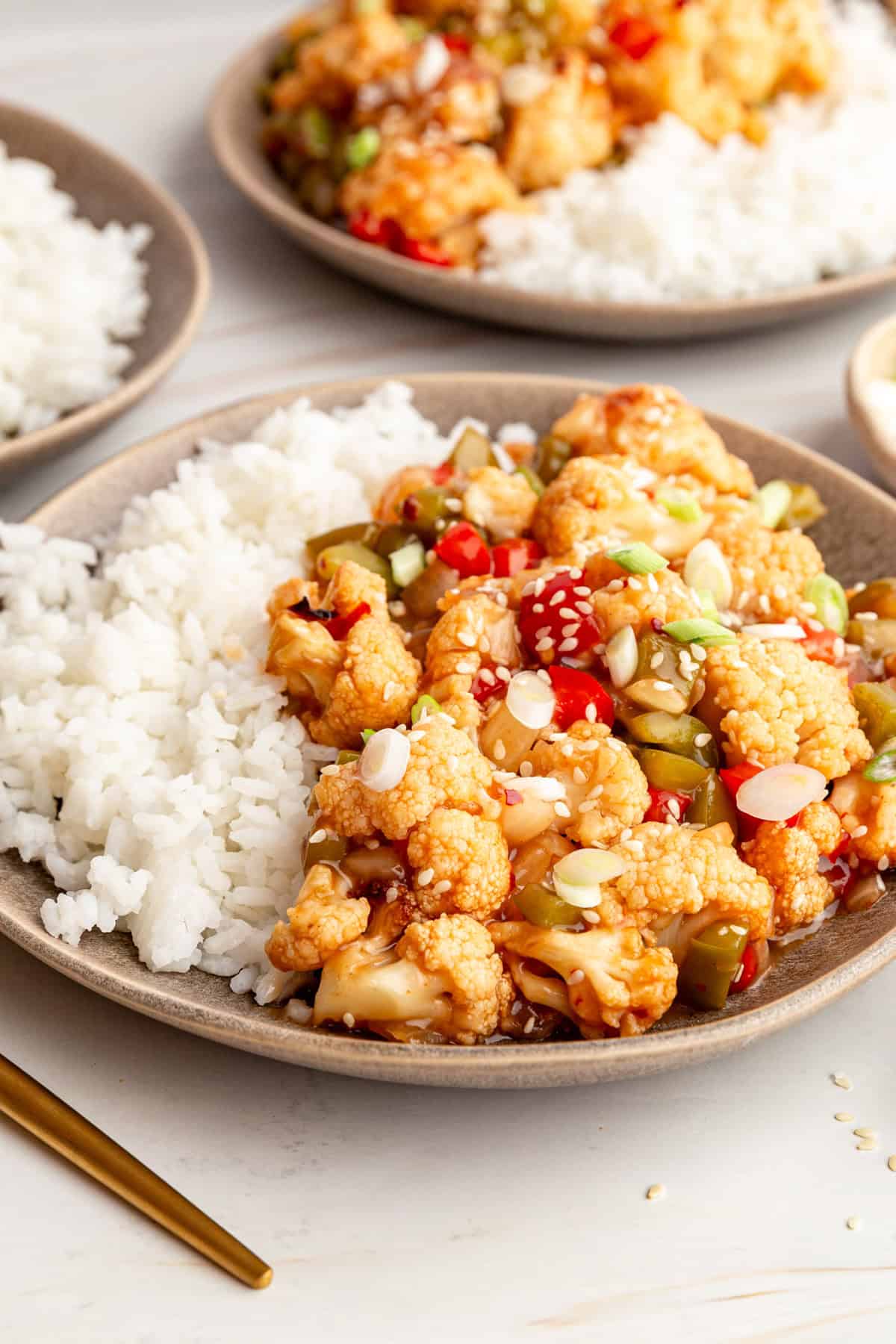A plate of sweet and sour cauliflower and rice, ready to serve.