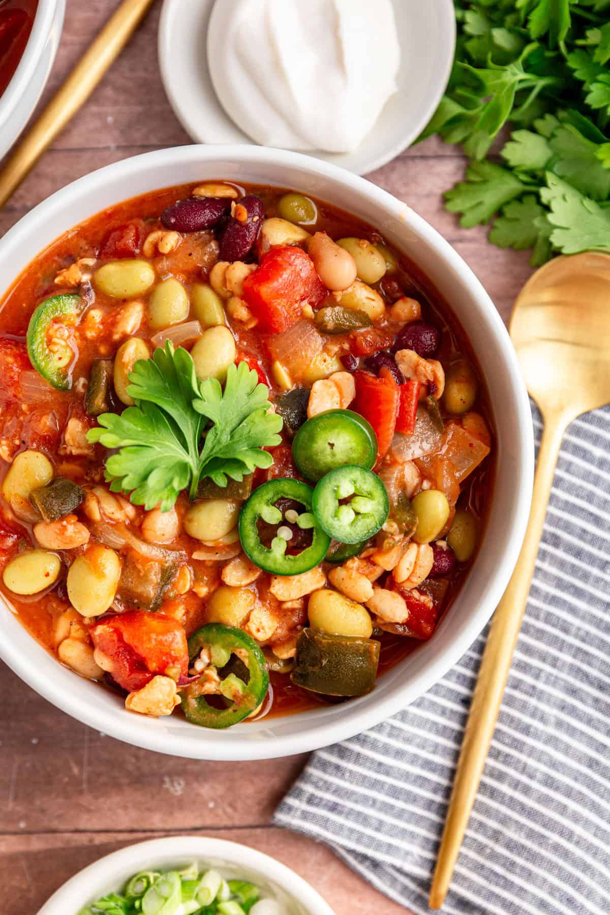 A bowl of vegan tempeh chili, garnished with jalapeño slices and cilantro.