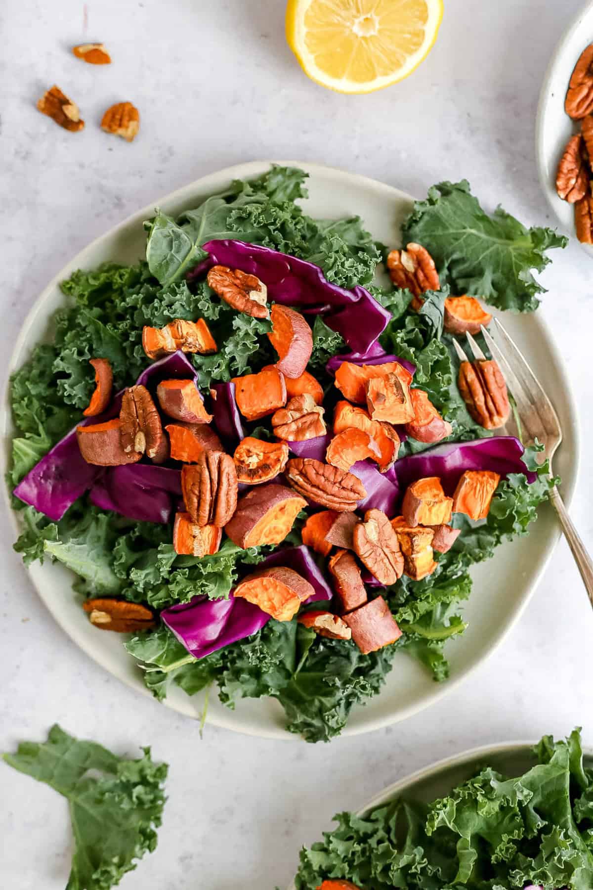 A sweet potato kale salad with a fork, ready to serve.
