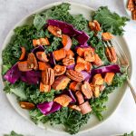 A sweet potato kale salad with a fork, ready to serve.