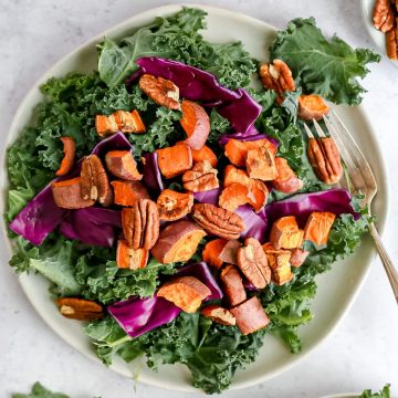 A sweet potato kale salad with a fork, ready to serve.