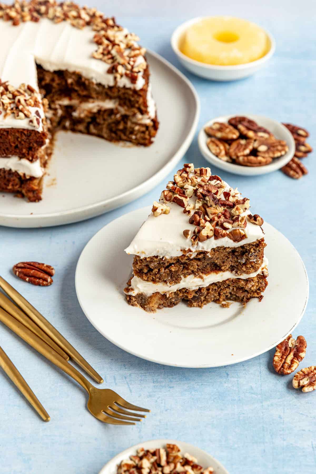 A hummingbird cake with a piece sliced and on a plate.