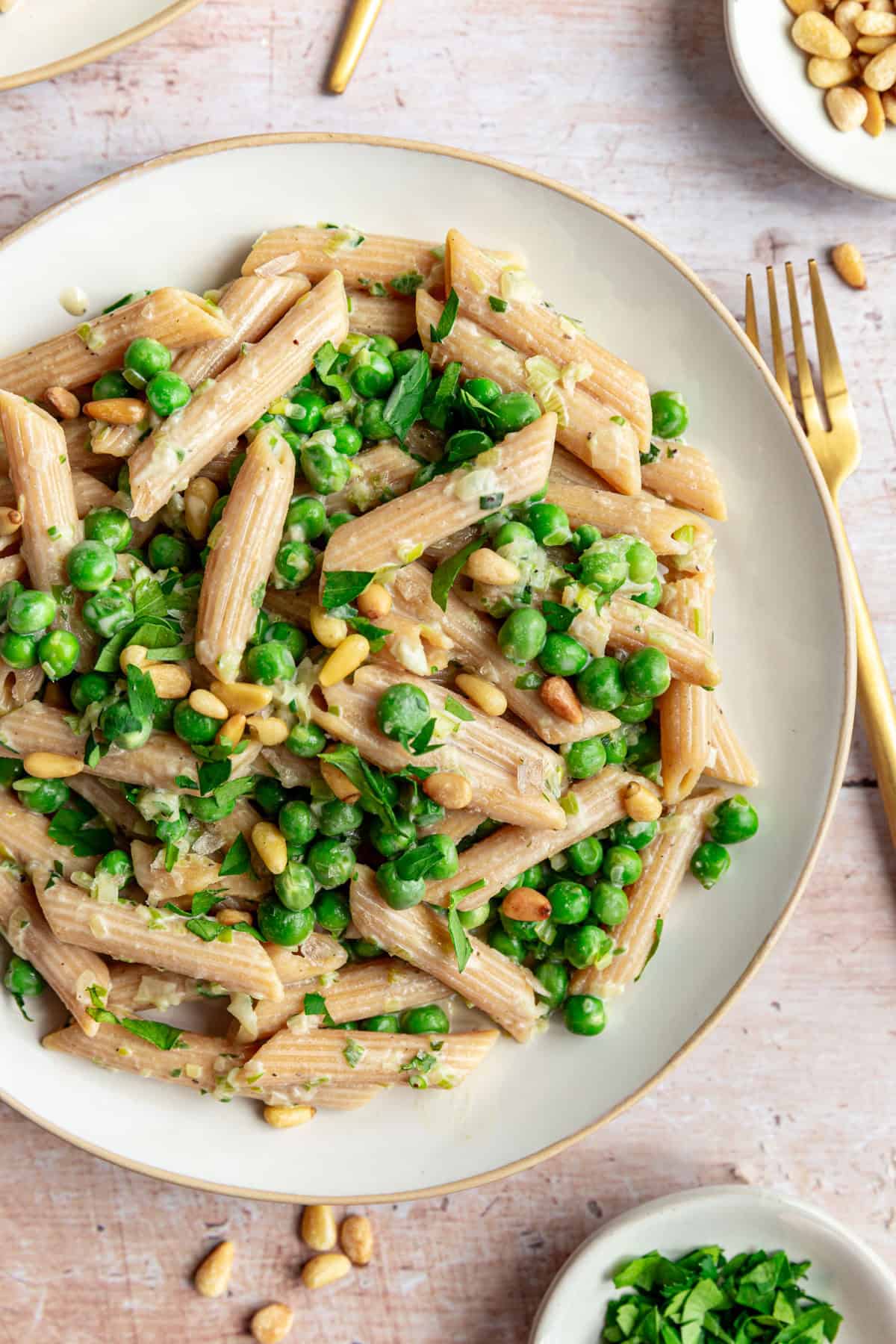 A plate of Vegan Pea and Spring Onion Pasta, with a fork, ready to serve.