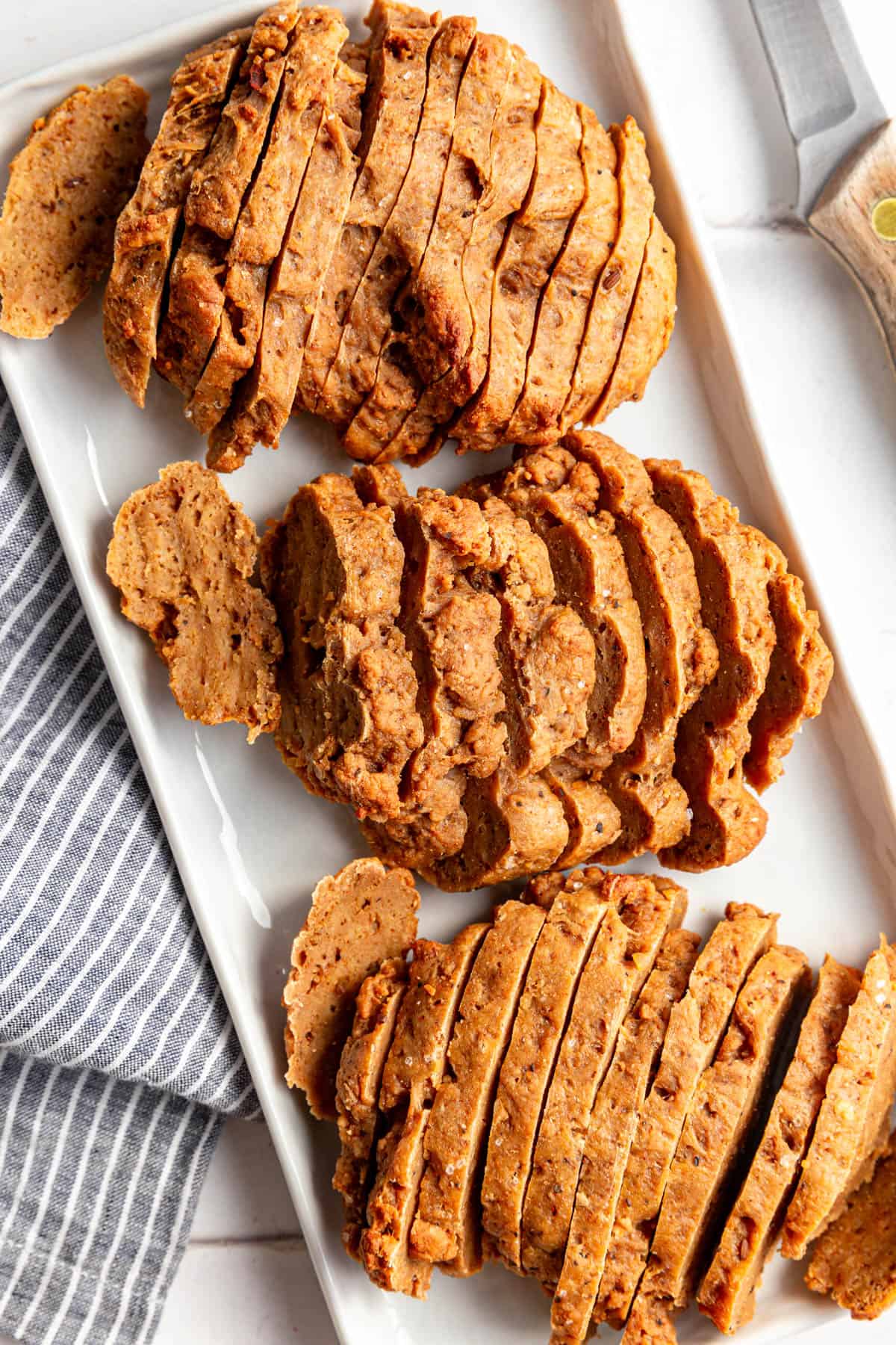 A tray of Vegan Seitan steaks sliced into strips.
