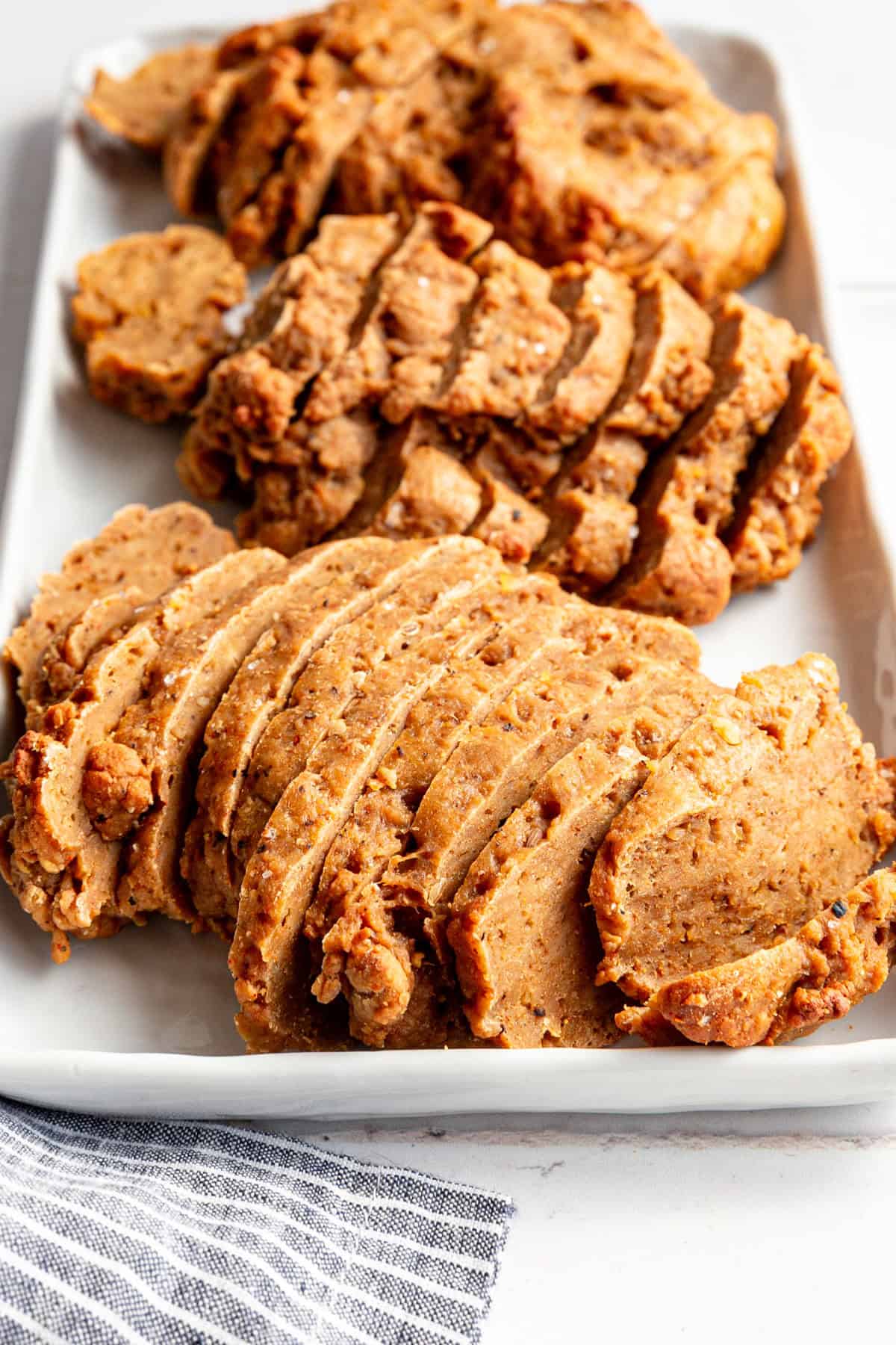 A tray of sliced seitan steaks.