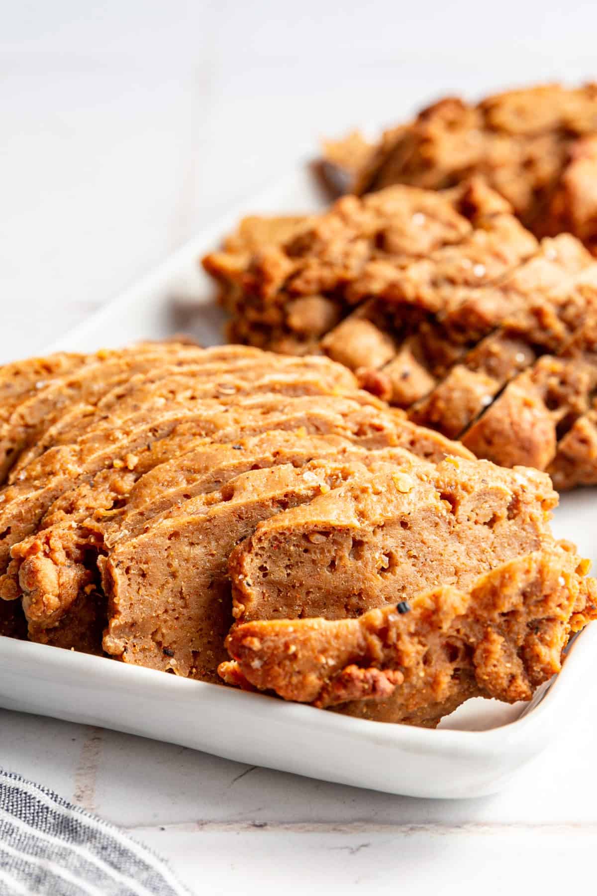 A tray of Vegan Seitan Beef sliced into strips.