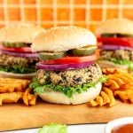 A Vegan Kidney Bean Burger on a bun with lettuce, onion, tomato, and pickles.