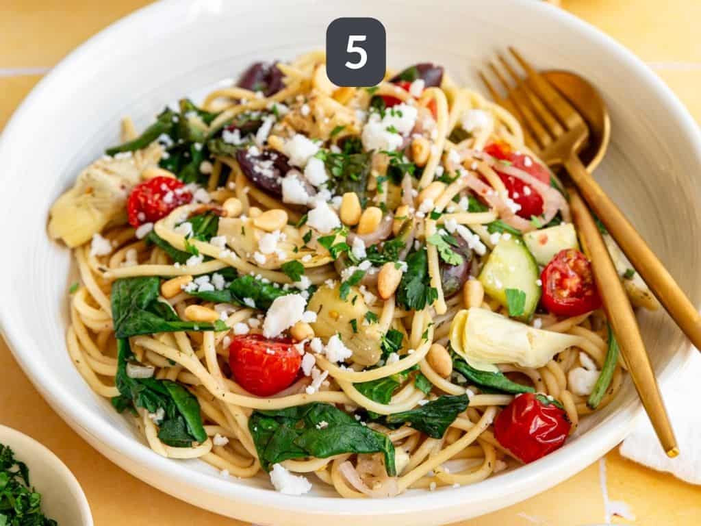 Vegan Mediterranean Pasta Step 5 - garnish with vegan feta, pine nuts, and parsley.