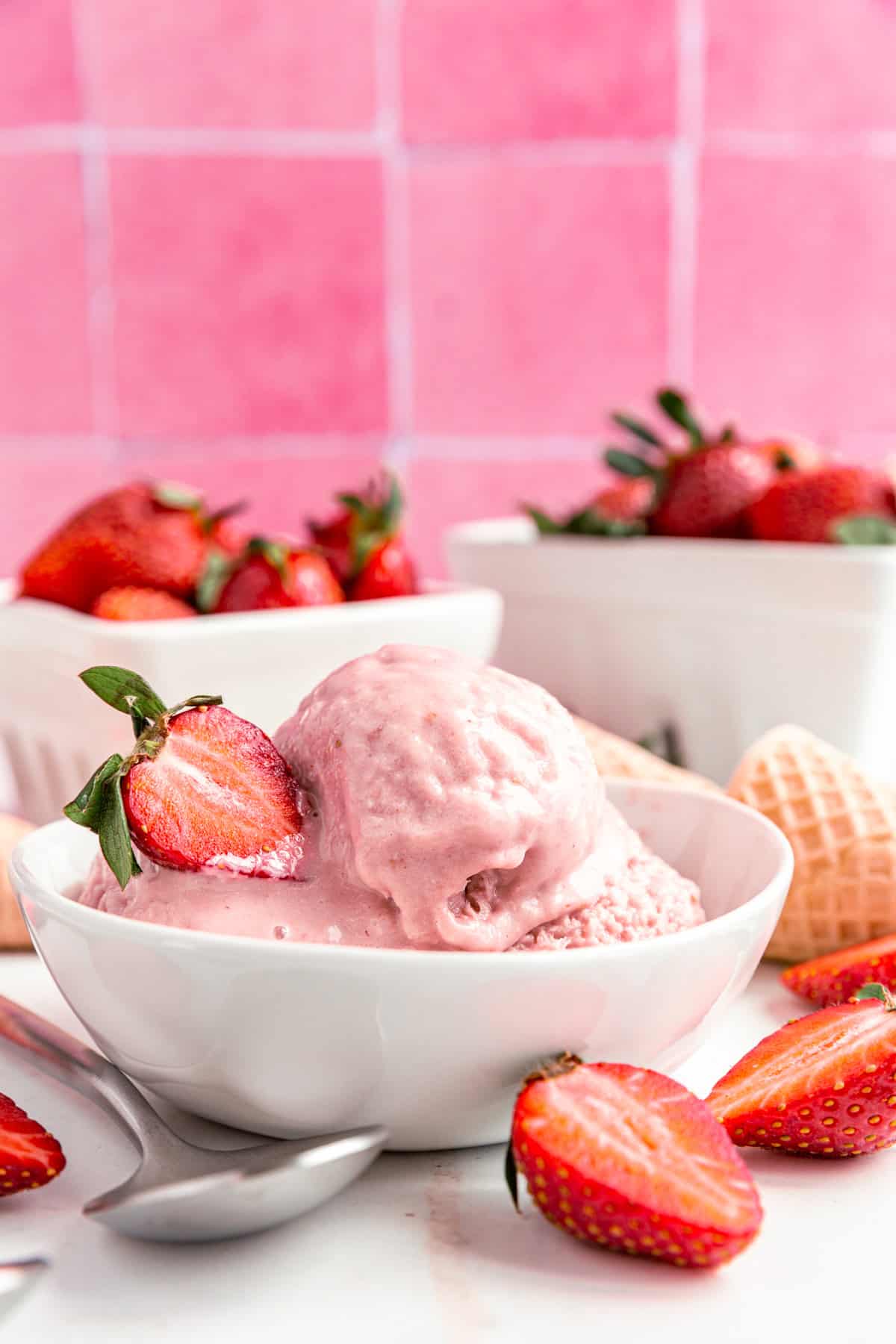 A bowl of Vegan Strawberry Ice Cream, with a strawberry, ready to eat.
