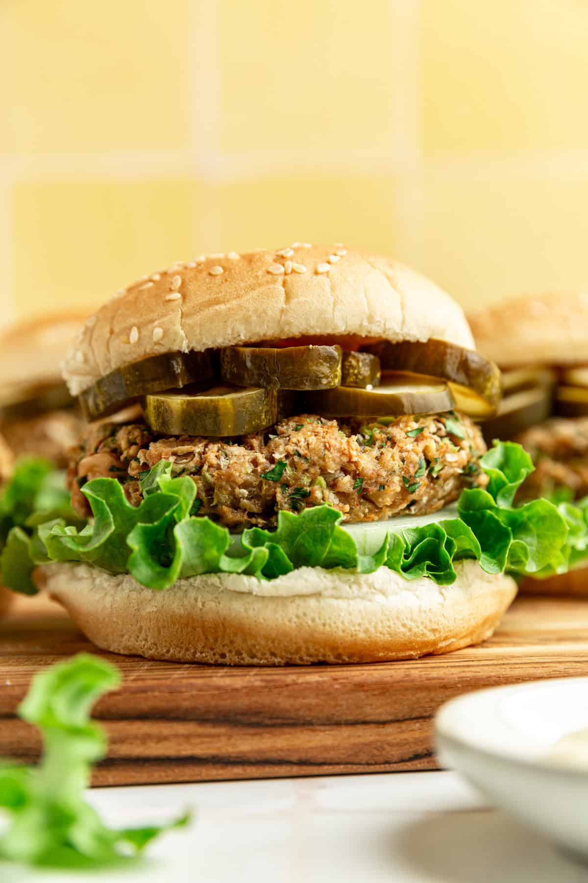 A vegan white bean burger on a cutting board, assembled and ready to serve.