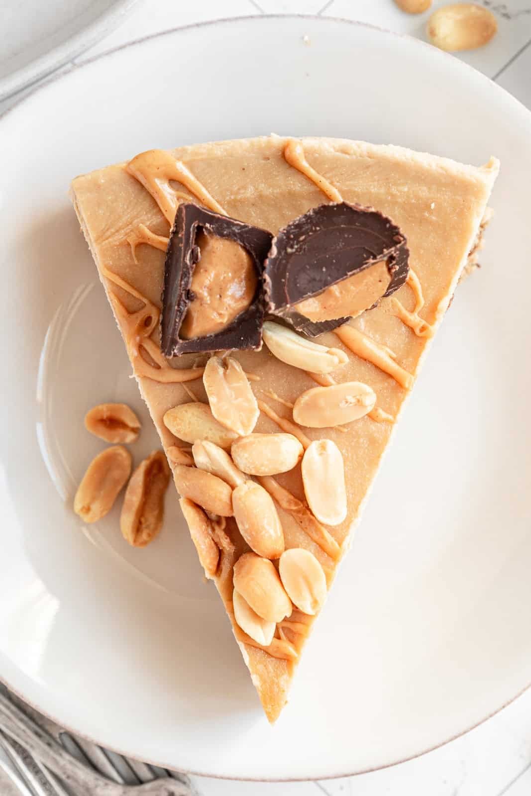 A plate of Vegan Peanut Butter Cheesecake with a garnish of peanuts.
