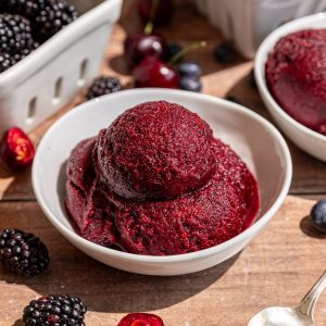 A bowl of melting berry sorbet in the sunlight.