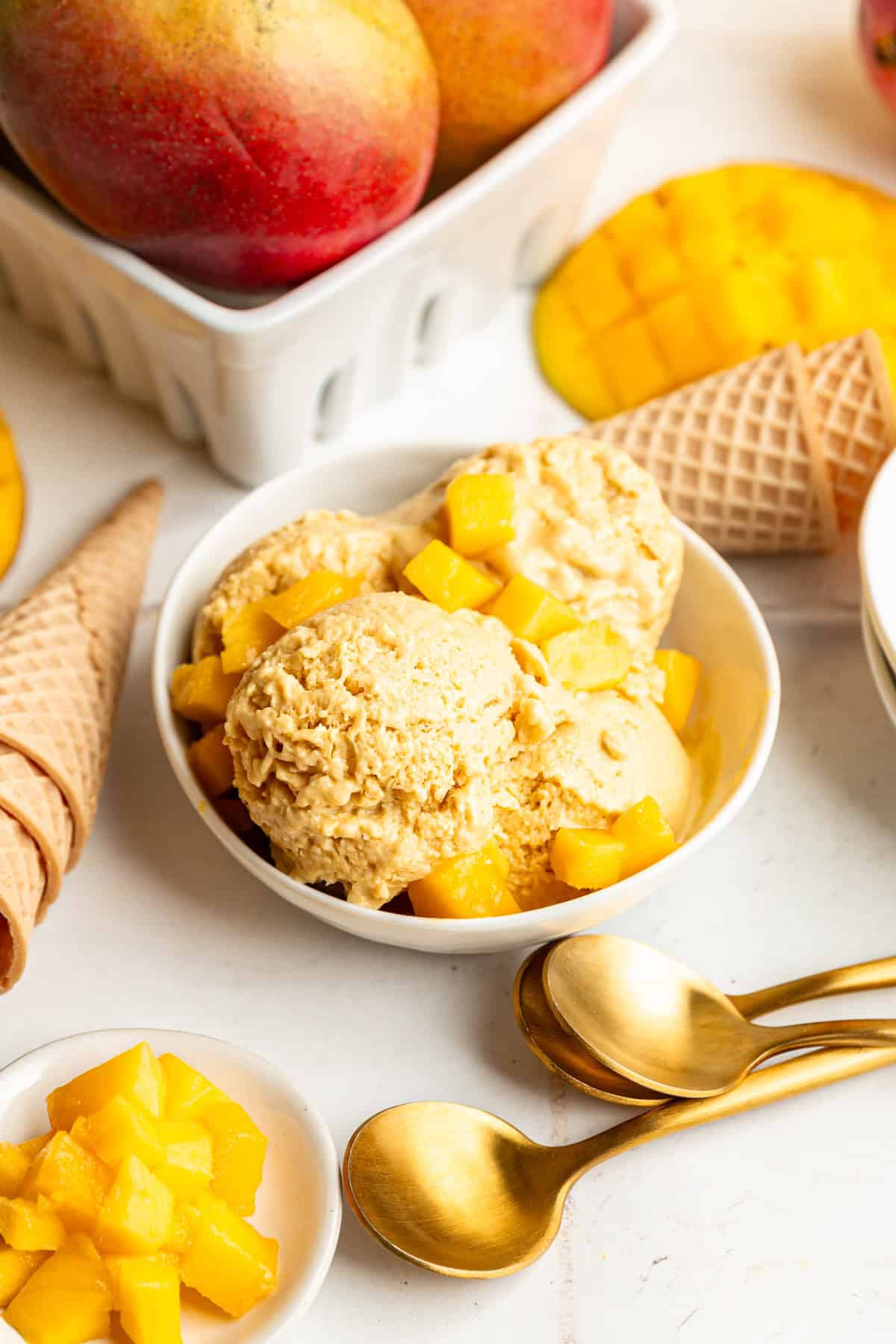 A bowl of vegan mango ice cream topped with fresh mango chunks.