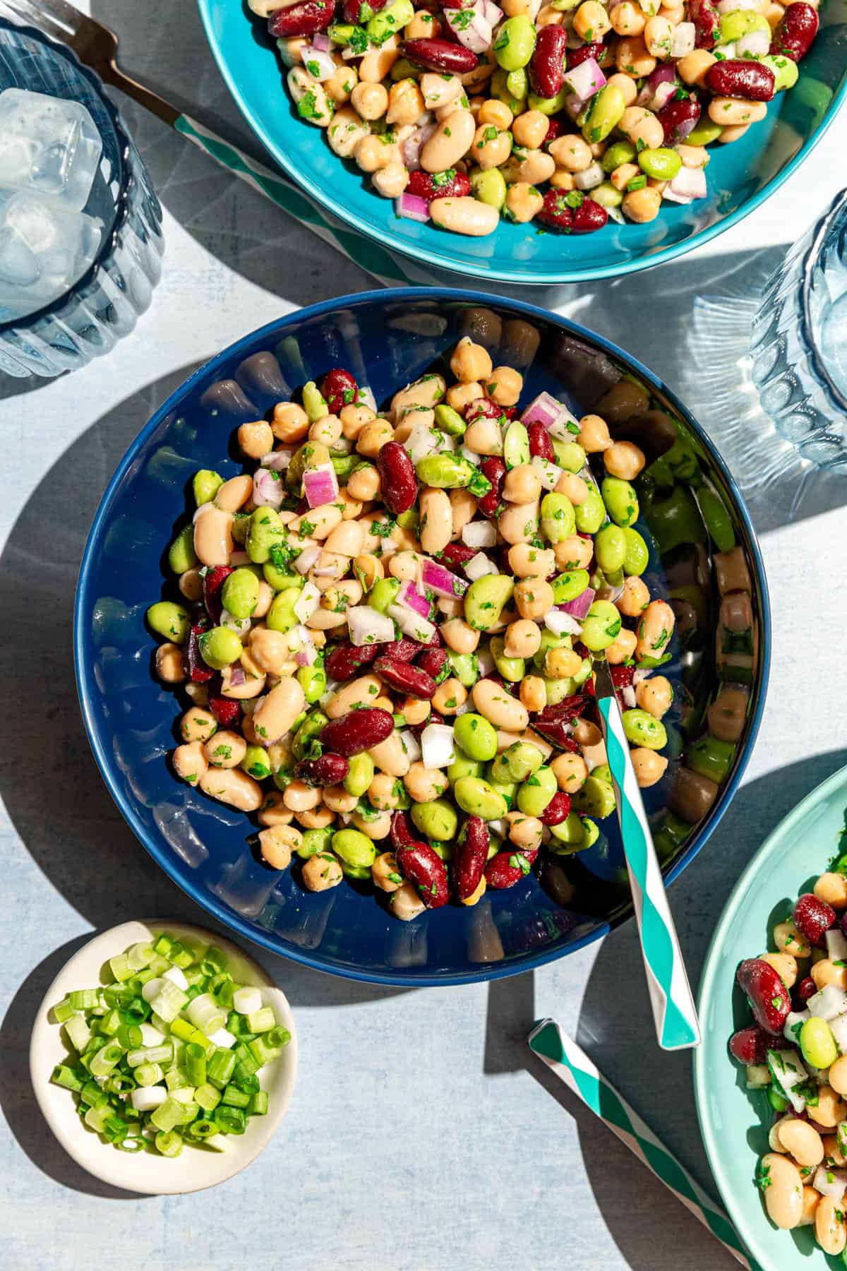 Several bowls of four bean salad in the sunlight.